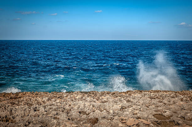 Waves splashing on rocks in the sea on a sunny day.