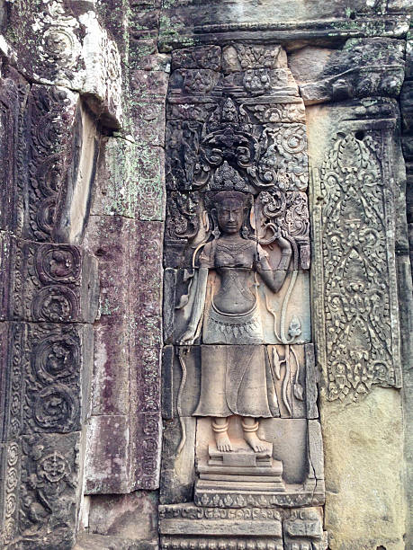Ancient Apsara dancer carving on a stone wall, showcasing intricate Cambodian art at Angkor Wat.