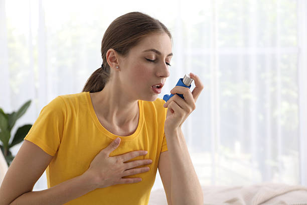 istock Young woman using asthma inhaler at home. Space for text 2215887638