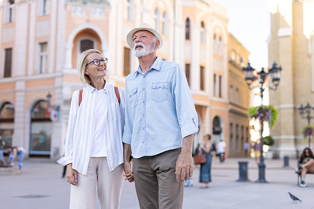 istock Elderly couple holding hands, exploring city streets in summer. 2215894676
