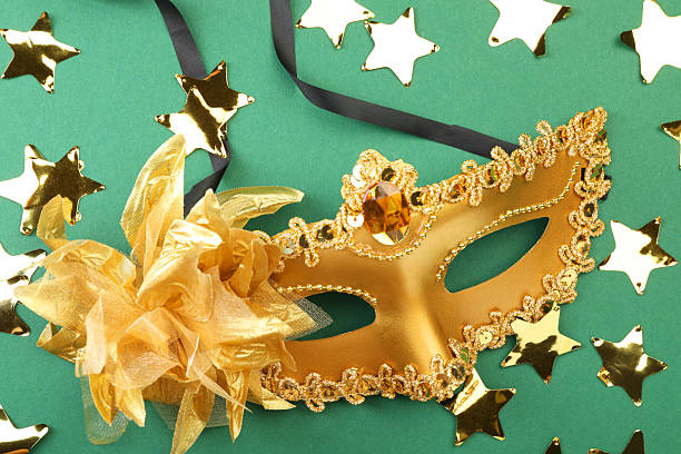 istock One golden carnival mask and confetti on green background, top view 2215898340