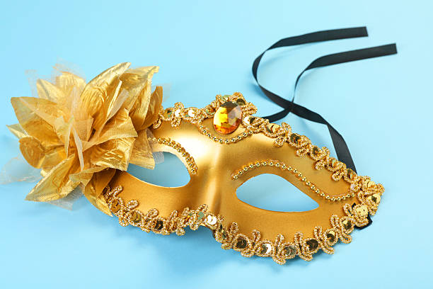 istock One golden carnival mask on light blue background, closeup 2215898345