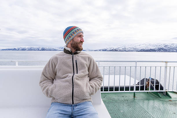 istock Man Relaxing on a Ferry in Winter Attire 2215900411