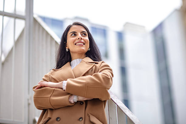 istock Businesswoman confidently poses outdoors while embracing success in a professional setting during a bright day 2215904999