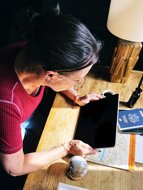 istock Woman sitting at table working on digital tablet 2215906015
