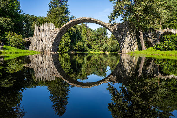 istock a semicircular arched bridge made of basalt stone over a pond reflected in the water 2215907050