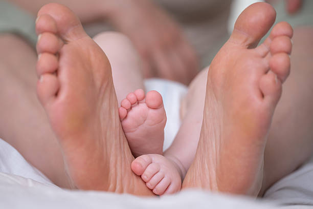 istock Tiny Toes, Giant Love: A tender moment shared between a parent and child, with the gentle touch of a tiny foot nestled against a nurturing embrace, whispering tales of boundless affection. 2215907677