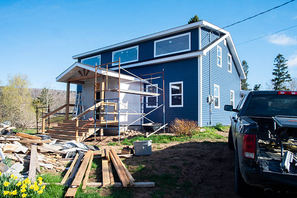 A house in a rural setting undergoing a major renovation. The front door is about to be installed.