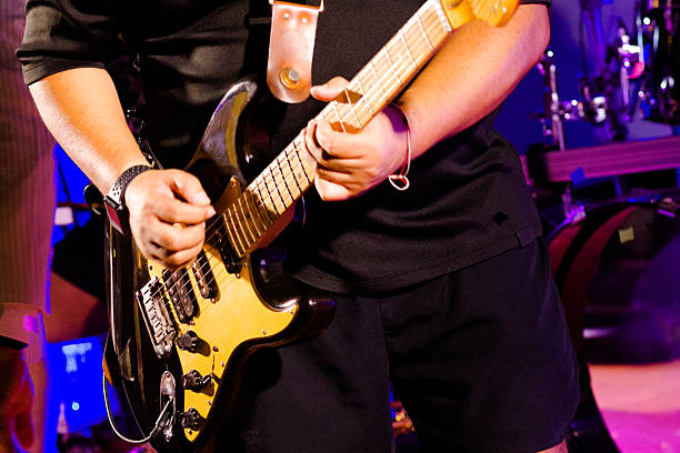 Two male guitarists playing a song together