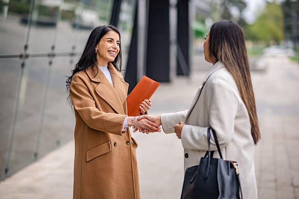 istock Businesswomen meet outdoors for networking and discussion in a corporate setting 2215914391