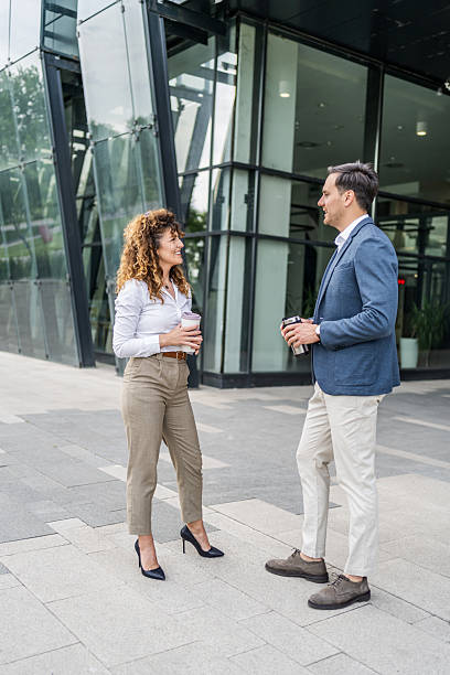 istock Business people talking and holding reusable coffee cups outside office 2215918256