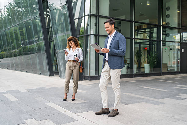 istock Businesspeople using digital tablet and smartphone outdoors 2215919195