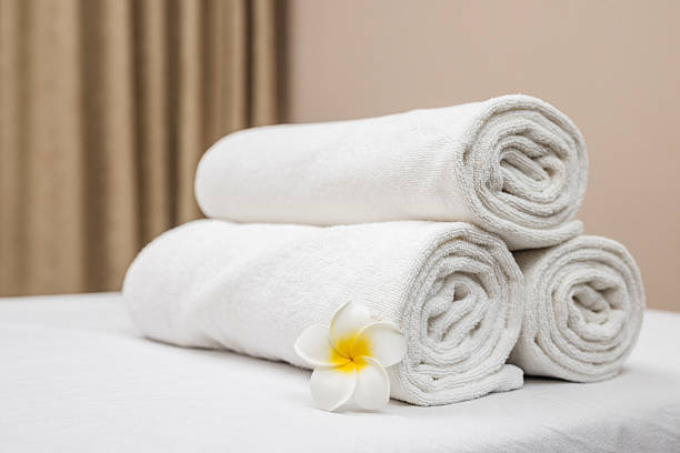 istock Spa composition: a rolled up towel and plumeria flower 2215919522