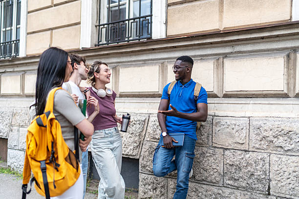 istock Cheerful university students chatting together outdoors 2215919567