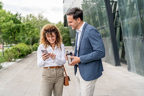 istock Businesspeople standing and using a smartphone outside office 2215919687
