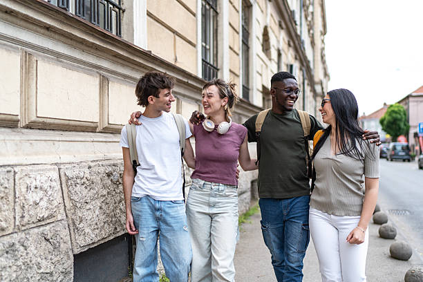 istock Group of young adults walking and laughing together 2215921425
