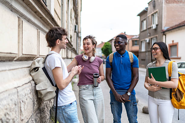 istock Cheerful university students chatting together on campus 2215921563