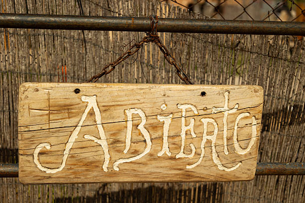 Sóller Mallorca, Spain - March 23, 2025 - Wooden sign with the word open written on it, hanging from a rusty railing
