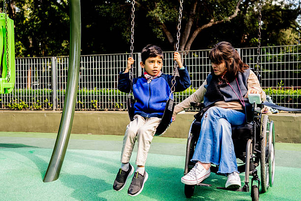 istock Child boy with his mother swinging at outdoors playground 2215922251
