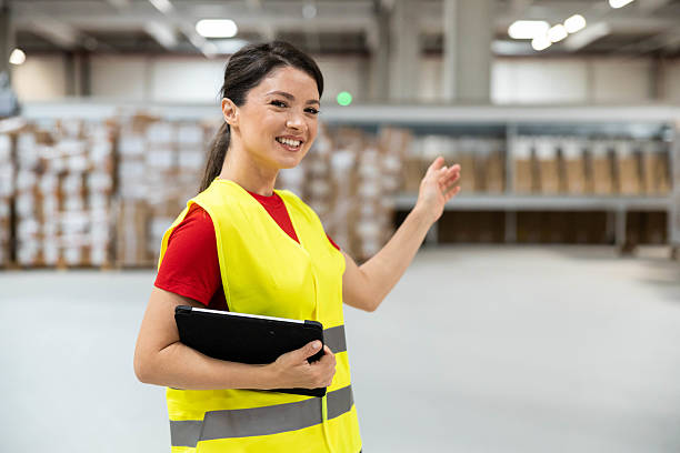istock Female warehouse worker pointing and explaining with tablet in hand 2215926349