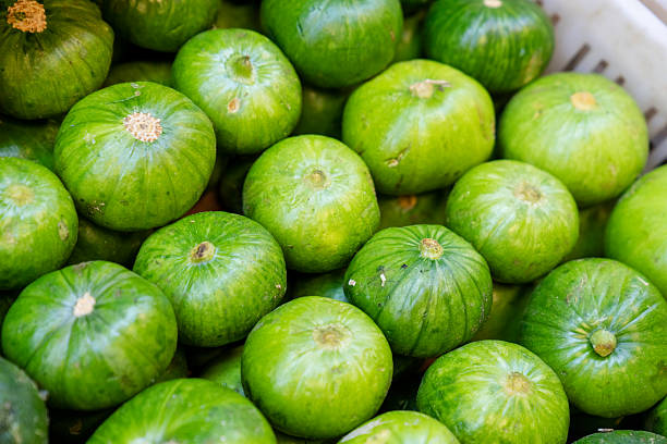 Fresh round zucchini on supermarket display. Smooth green vegetables placed together, offering customers a selection of ripe and firm produce.