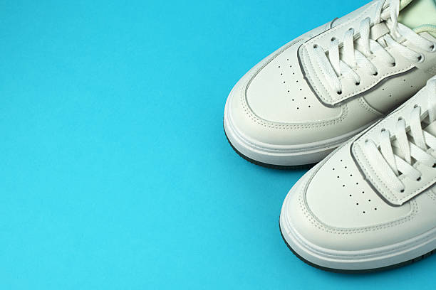 istock Pair of White Sneakers on Blue Background with Copy space 2215929169