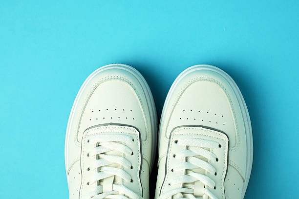 istock Pair of White Sneakers on Blue Background with Copy space 2215929172