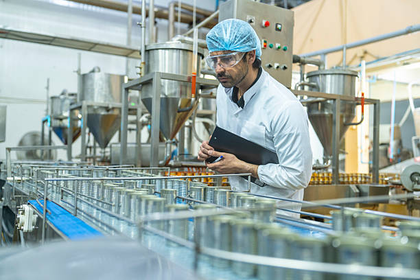 istock Professional closely examining production materials on a conveyor system, representing dedication to quality, precision, and modern technology in manufacturing processes. 2215930662