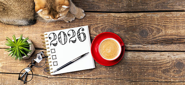 istock New year resolutions 2026 on desk. 2026 resolutions list with notebook, coffee cup, cute cat on table. Goals, resolutions, plan, cozy, hygge concept. New Year 2026 template 2215930878