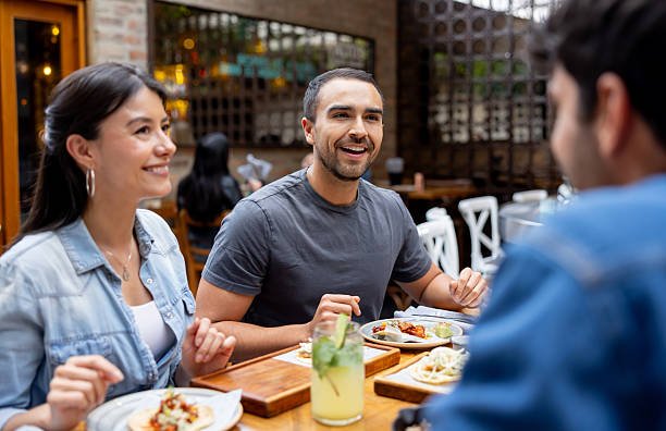 istock Happy man having dinner with a group of friends at a restaurant 2215930978