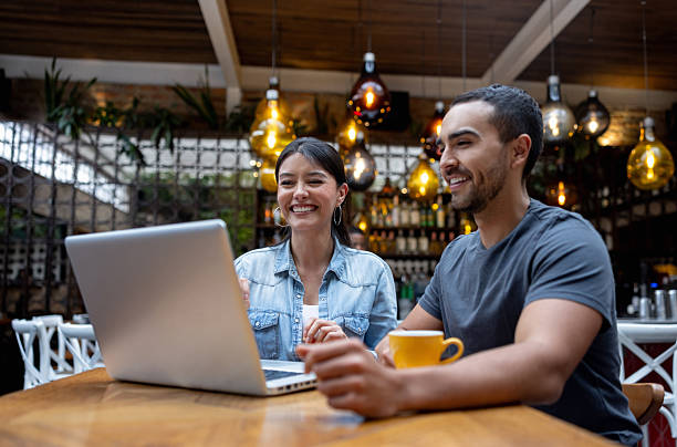 istock Two people working on a laptop at a restaurant and smiling 2215931018