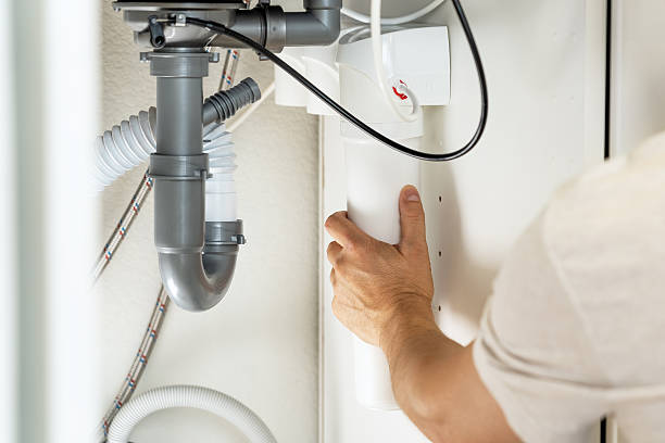 istock Close up of plumber hands installs water purifier. Replacement water filter 2215931696