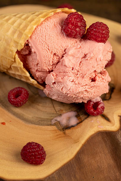 istock pink ice cream lies on a walnut board close up, ripe red raspberries and raspberry cold natural ice cream on the table 2215934075