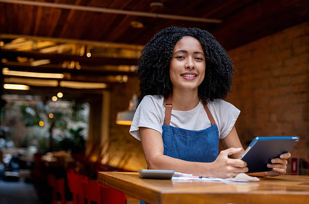 istock Happy waitress doing the books at a restaurant 2215934603
