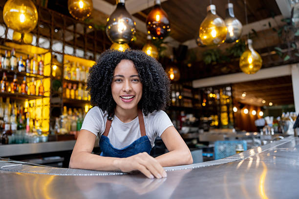 istock Happy bartender smiling behind the counter at a bar 2215934604