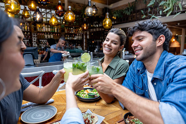 istock Happy friends at a restaurant toasting while having dinner together 2215934747