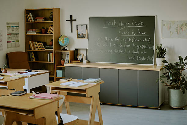 istock Bright Classroom with Chalkboard and Desks Organized 2215935424