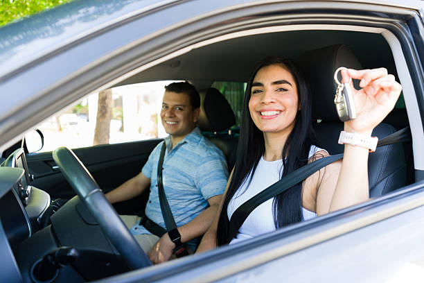 istock Happy couple showing new car keys while driving 2215935474