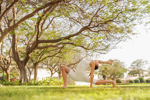 istock Woman practicing yoga outdoors under trees in a calm and serene environment 2215938358