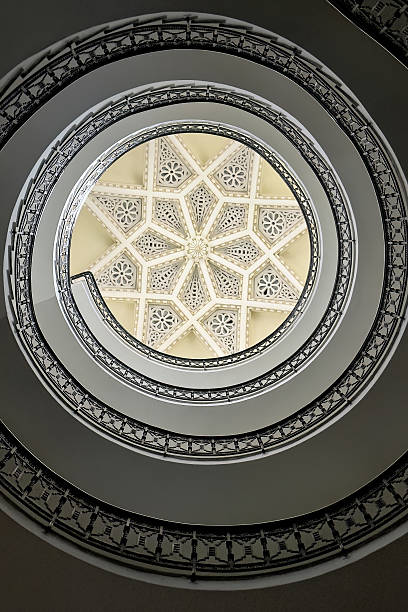 Artistic spiral staircase with intricate railing and central skylight in Ceuta.