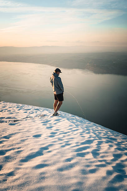 Hiker on snowy mountain ridge above lake, Mount Grammont, Valais, Swiss Alps