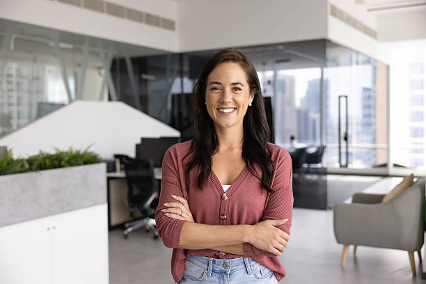 istock Happy young lady posing with arms crossed in modern office 2215940257