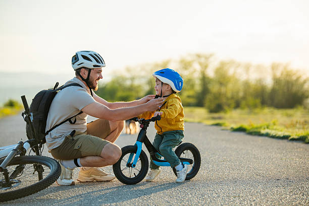 istock Safety first my boy! Preparing helmets and getting ready for cycling. 2215940760