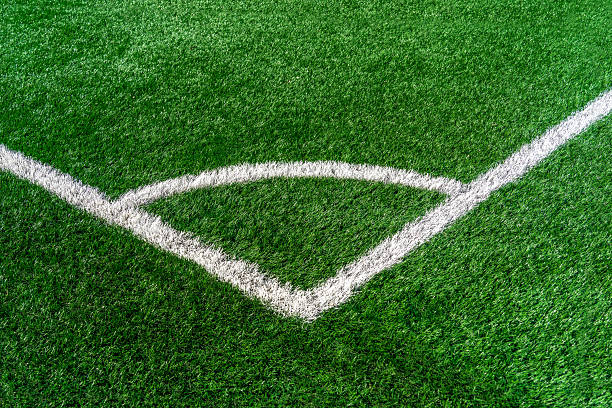 Soccer field corner white marking with artificial synthetic green grass turf
