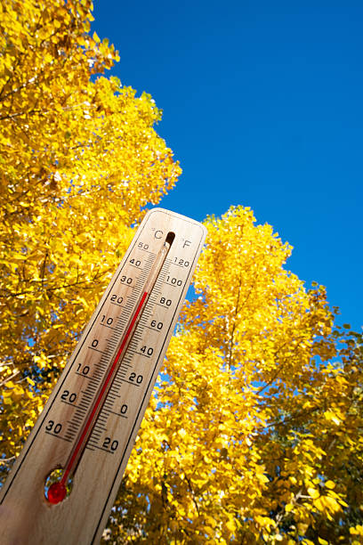 istock Thermometer with high temperature against background yellow autumn trees and blue sky. 2215952485
