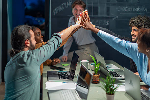 istock Startup team giving high five celebrating success in office meeting 2215953351