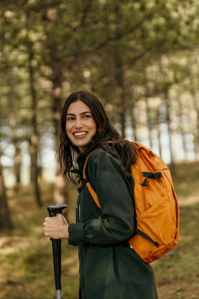 istock Young female hiker exploring forest trail with backpack and trekking pole 2215955537