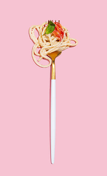 istock Fork with creamy spaghetti, tomato and basil on isolated pink background. 2215959001