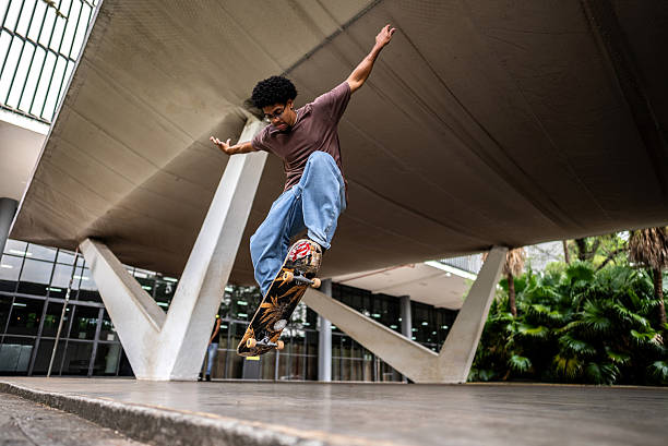 istock Young woman doing skateboard trick at public park 2215962714