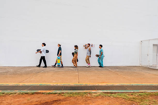 istock Skater friends walking around white wall 2215962824